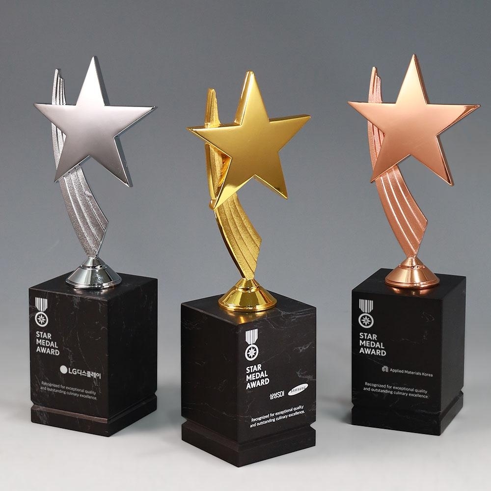유니크한 별 조형의 상단부와 고급스러운 블랙 천연대리석 베이스가 조합된 디자인으로, 시상식 트로피 및 스포츠 트로피 제작에 적합한 금색, 은색, 동색 트로피시리즈 입니다.